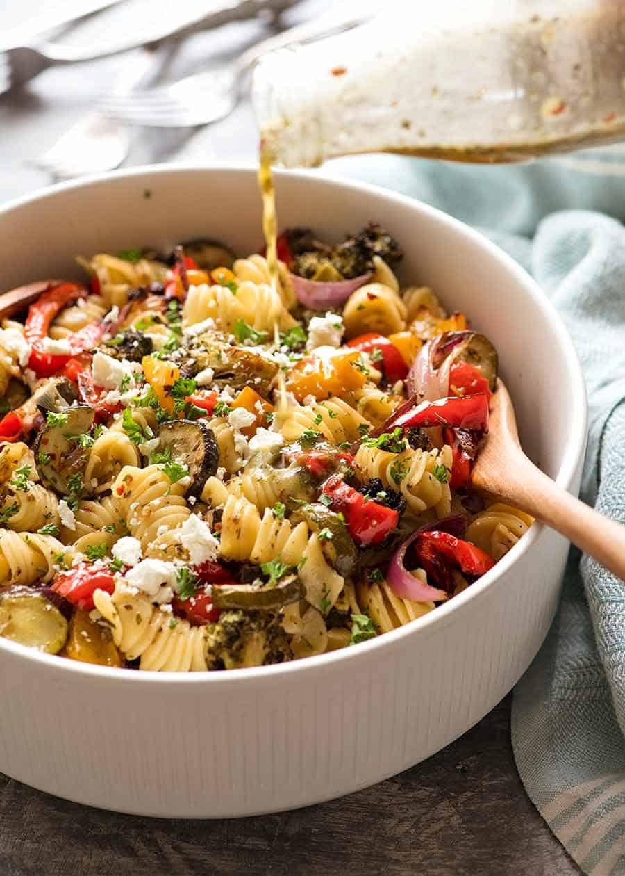 marinated-vegetable-pasta-salad_4 Pouring lemon garlic pasta salad dressing over Vegetable Pasta Salad