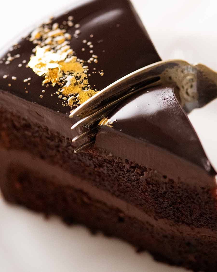 slice-of-chocolate-mirror-glaze-cake_2 Close up of fork cutting into a slice of Chocolate Mirror Glaze Cake