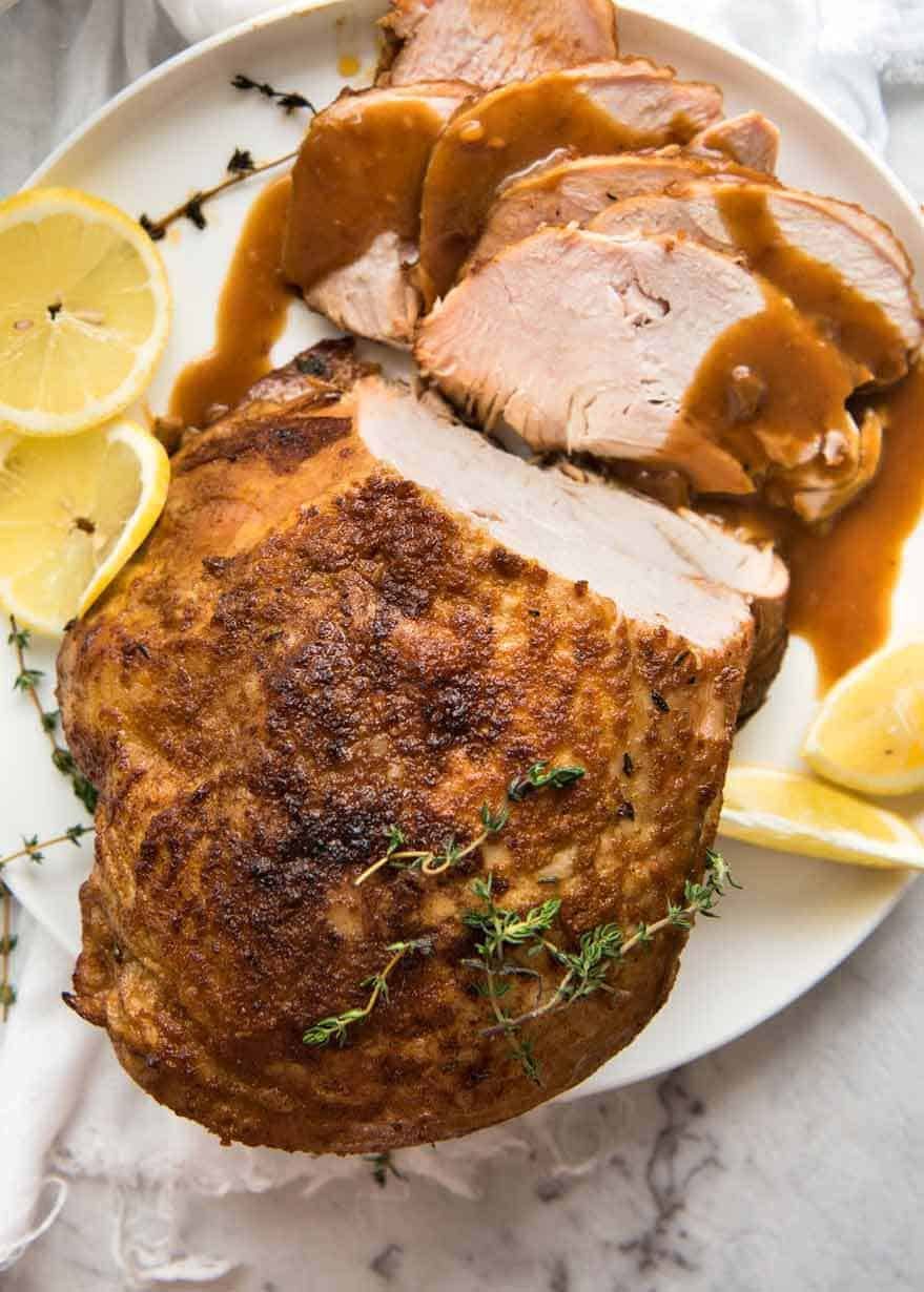 slow-cooker-turkey-breast_1a Overhead photo of Slow Cooker Turkey Breast on a white plate with some slices carved, drizzled with gravy