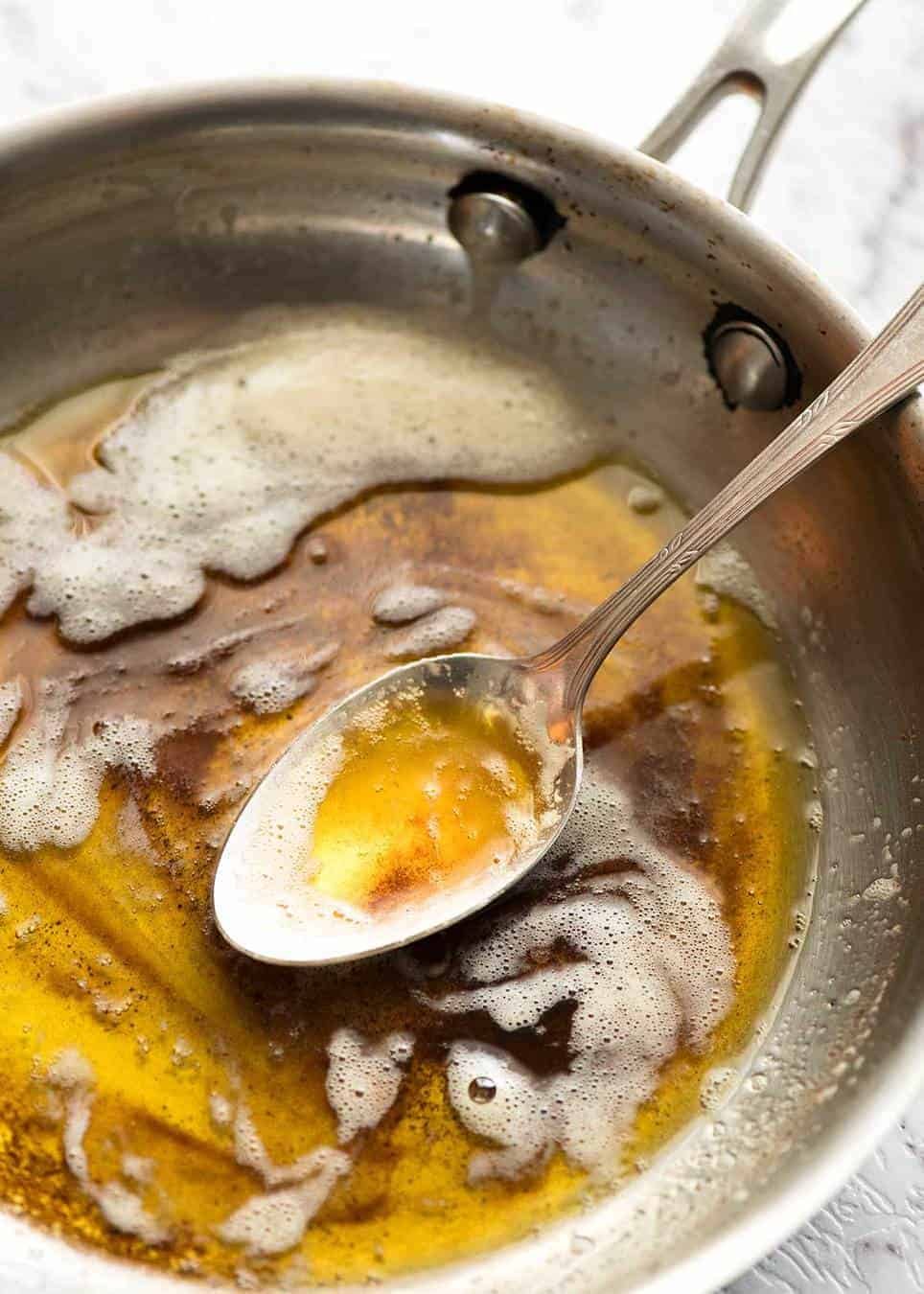 fish-with-lemon-butter-sauce_7 Brown butter in a small silver skillet with a spoon.