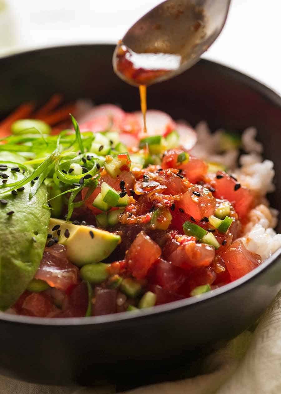 Drizzling dressing over Poke Bowl
